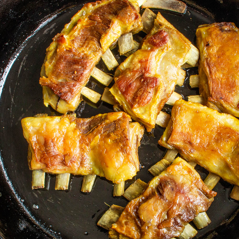 indian lamb ribs crisping in a pan