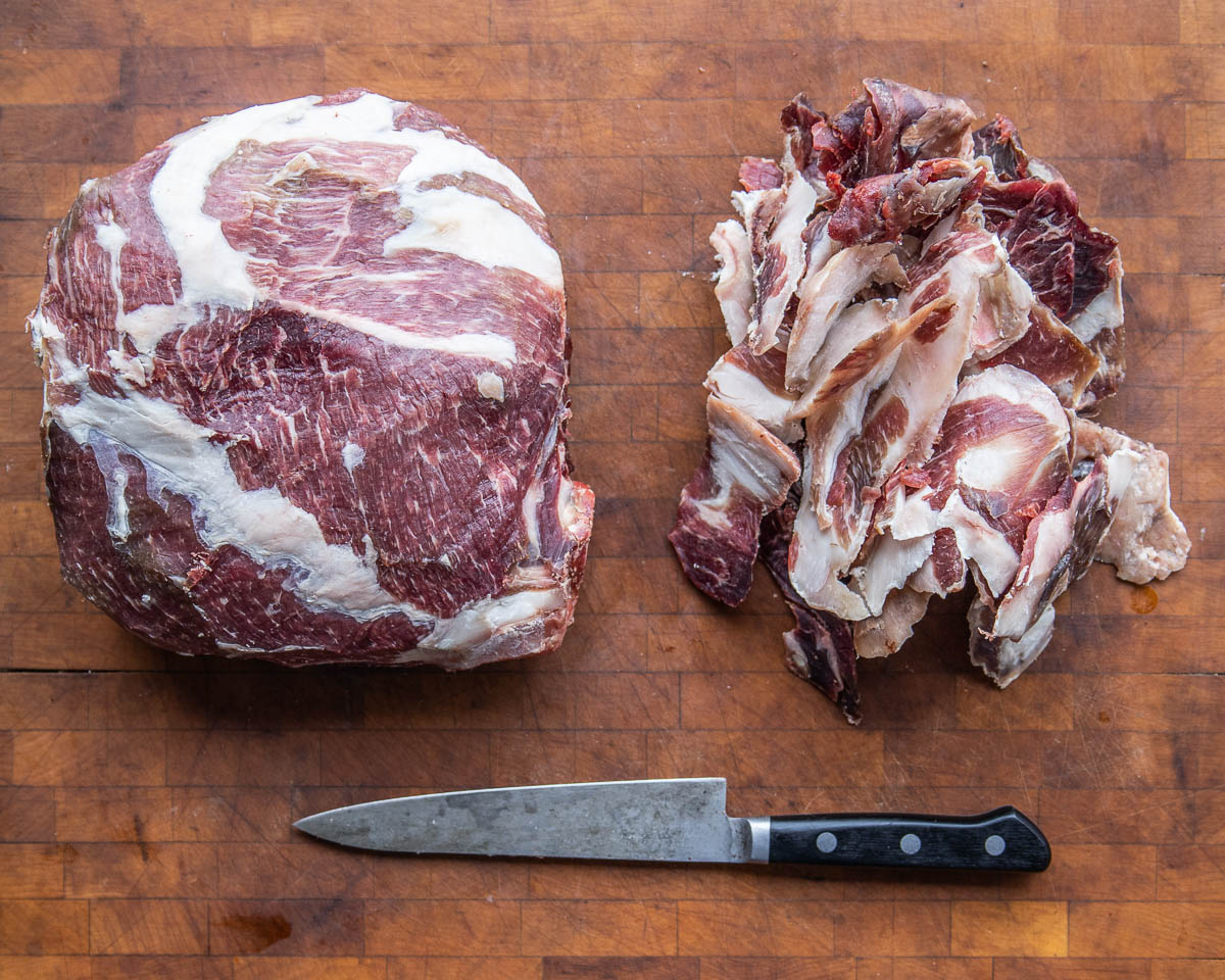 trimming the pellicle from a dry aged mutton leg