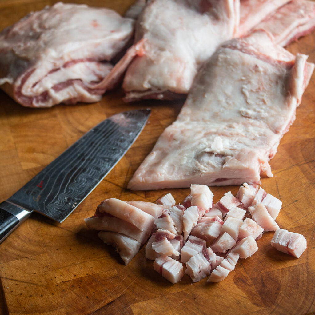 Cutting lamb fat caps for chicharrones de borrego
