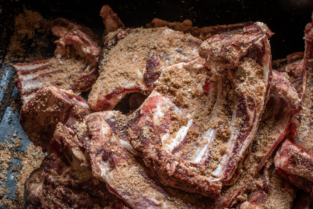 Rubbing lamb bones with bacon cure