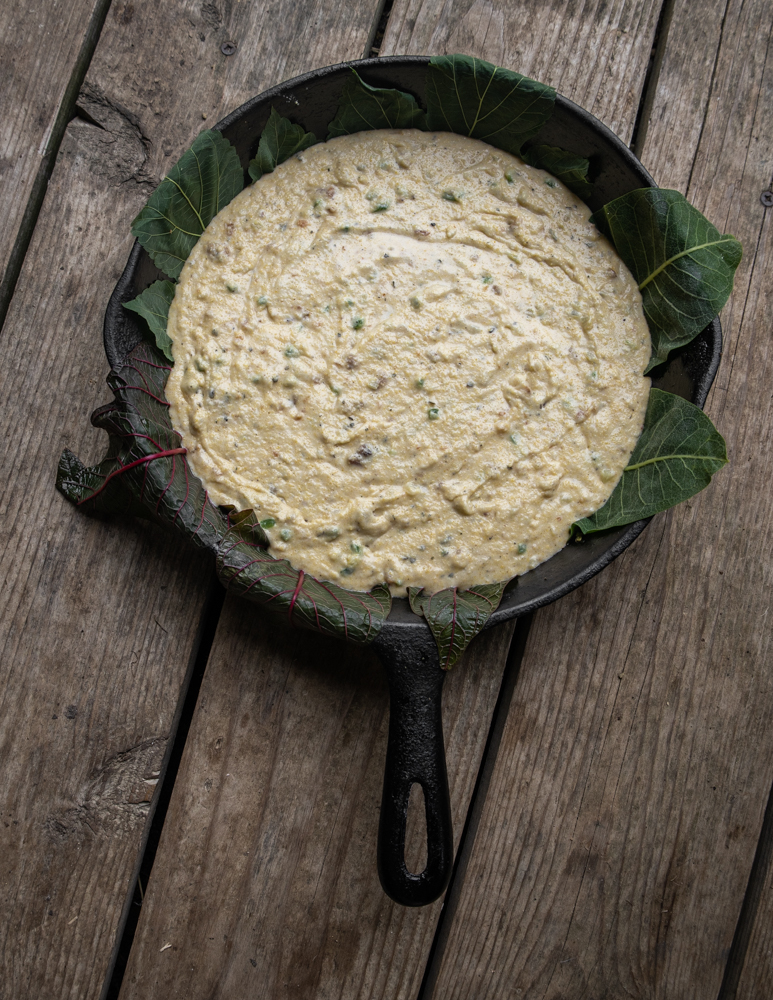Lining a pan with foraged leaves to make cornbread