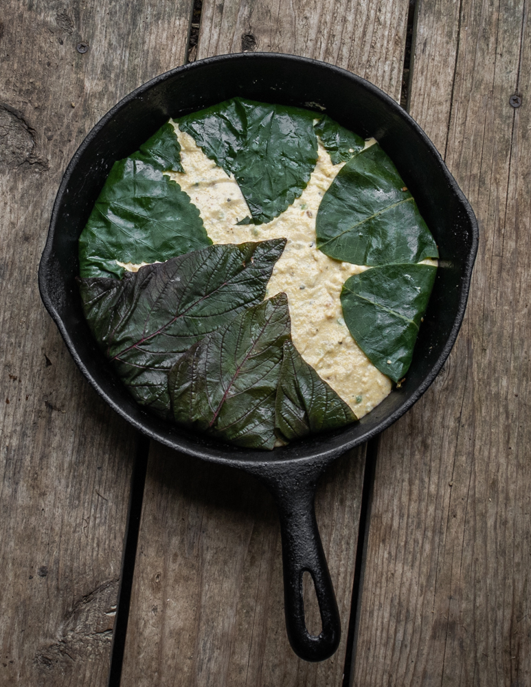 Lining a pan with foraged leaves to make cornbread
