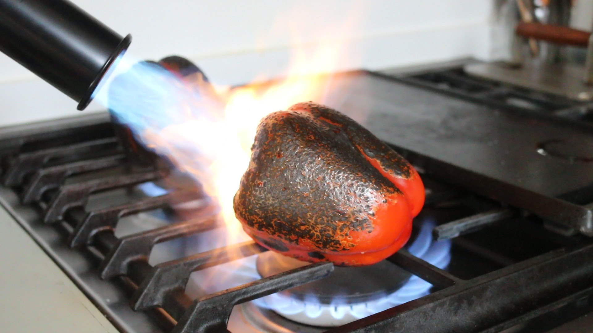 Roasting a pepper with a torch 