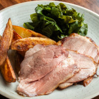 Sliced brined and smoked leg of lamb on a plate