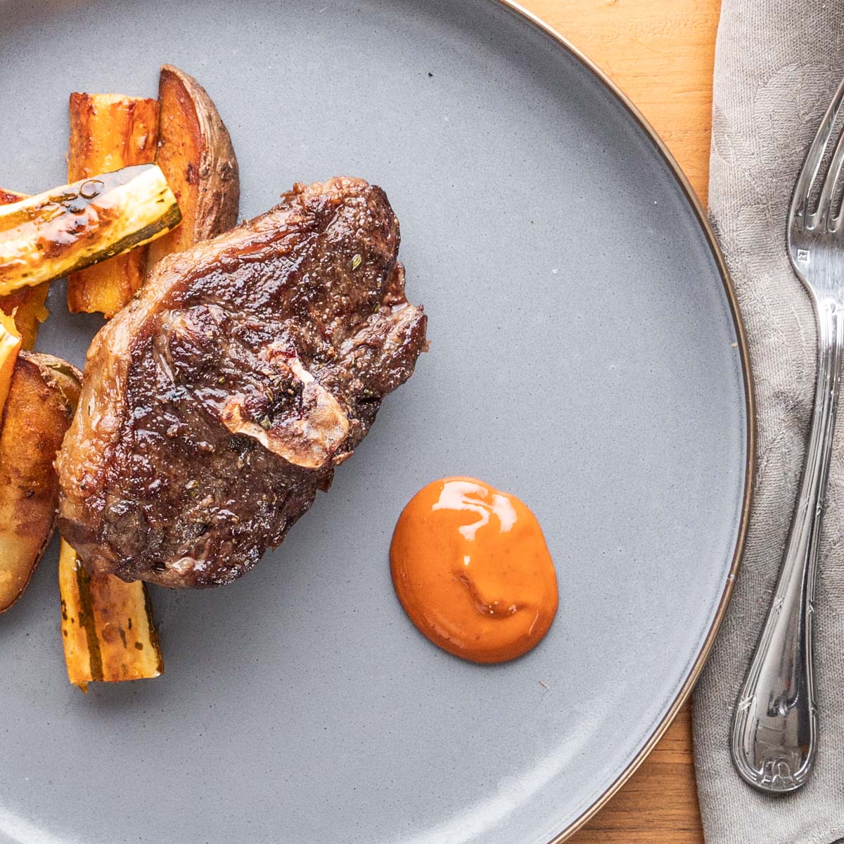 barnsley chops with vegetables and mustard sauce on a plate.